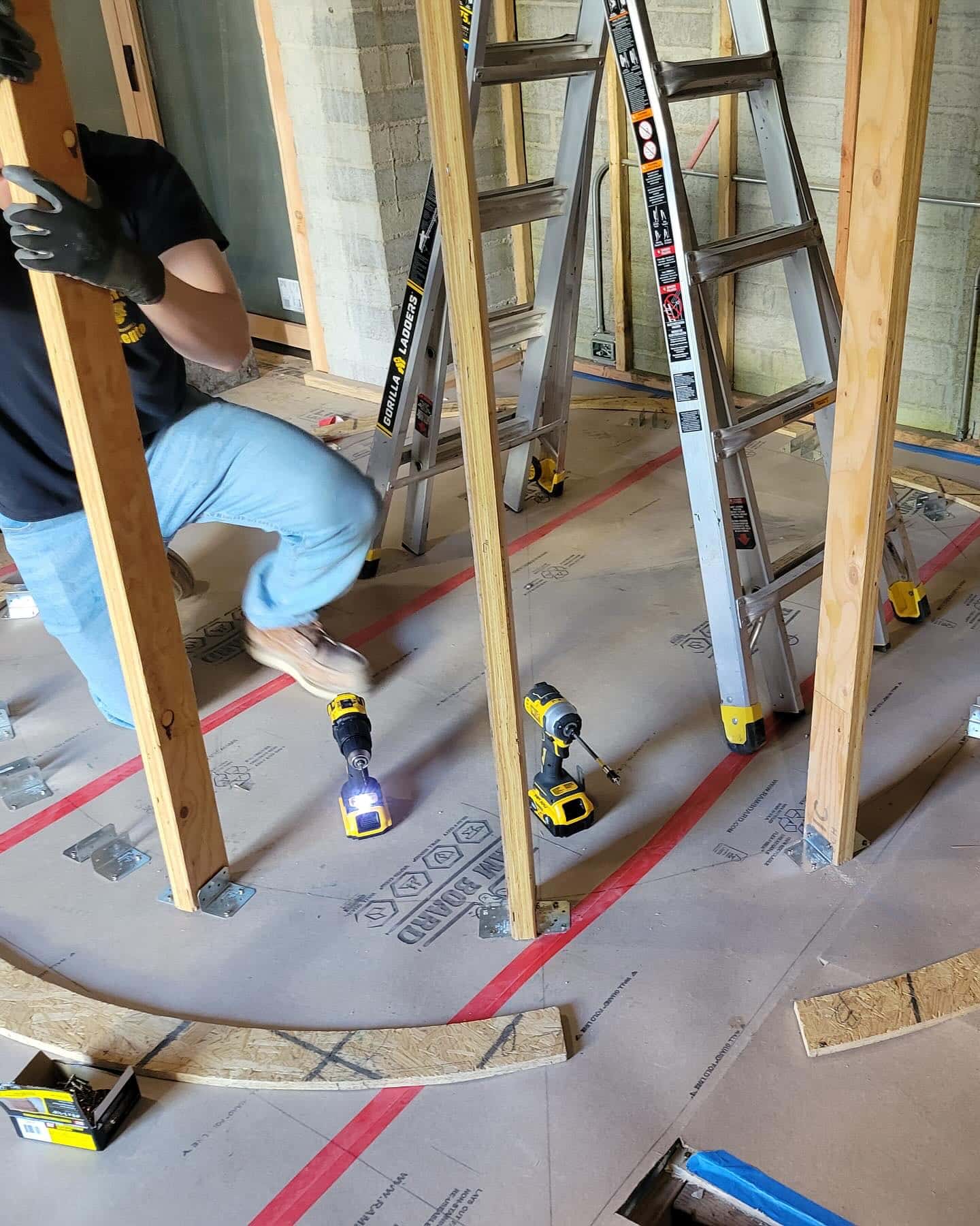 Laying out the spiral stair footprint with a circle scribed on the floor and vertical studs.