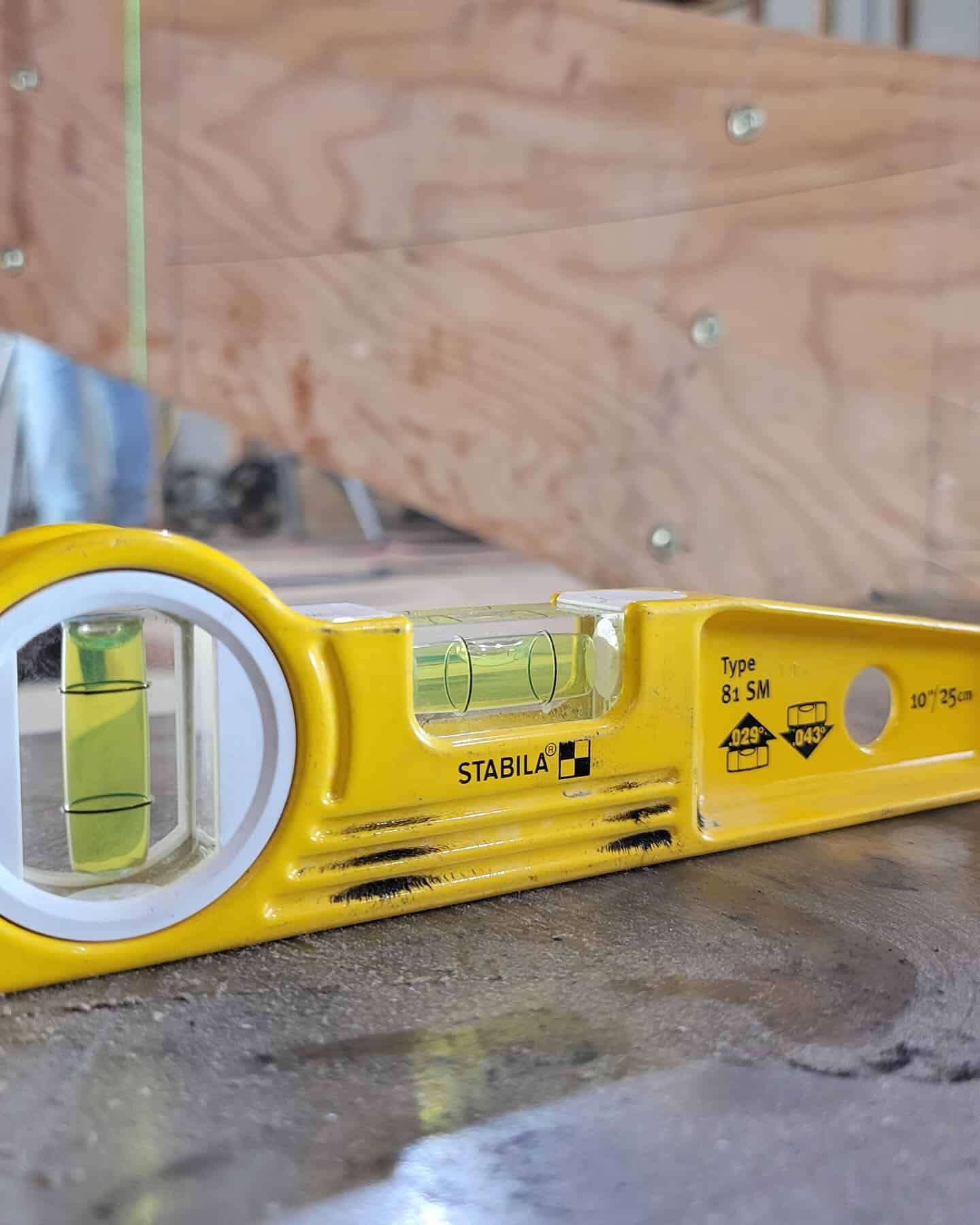 Level tool placed on a tread to verify flatness and consistent rise.